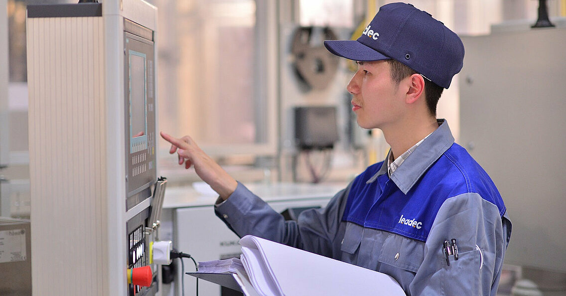 Leadec employee checking data of machine on display. 