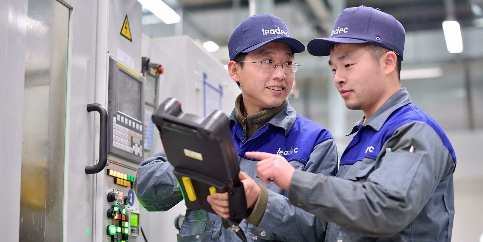 Two Leadec employees with tablet at plant.