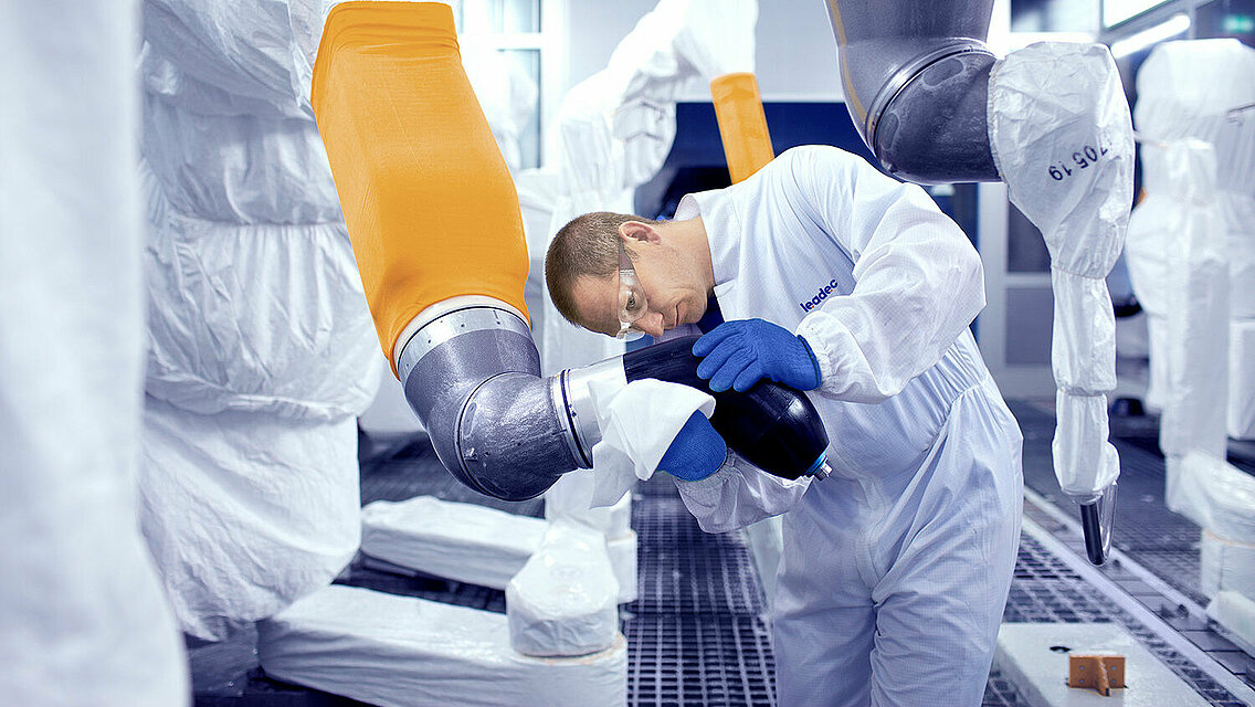 Leadec employee cleaning robot in a paint shop. 