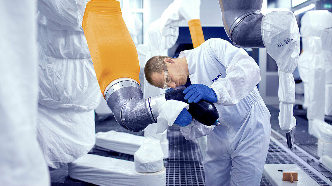 Leadec employee cleaning robot in a paint shop. 