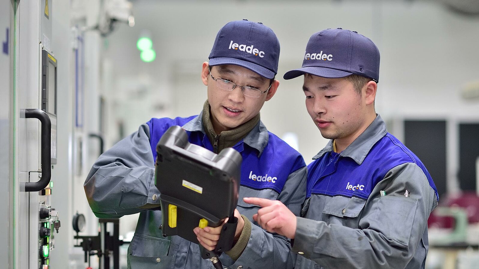 Two Leadec employees checking data on a tablet.