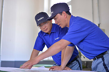 Two Leadec employees discussing plan of logistics plant.