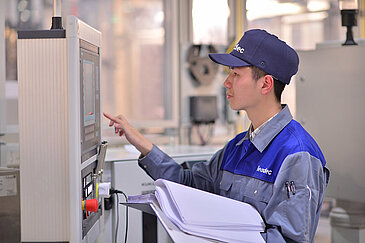 Leadec employee checking data of machine on display. 